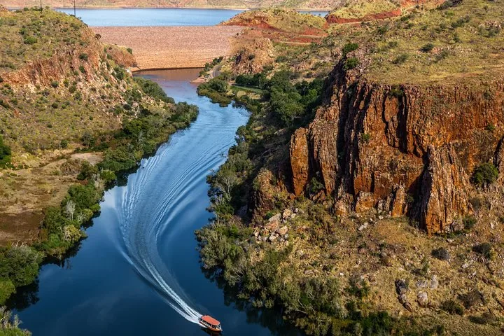 Vista aérea de un barco en un río que serpentea por un desfiladero